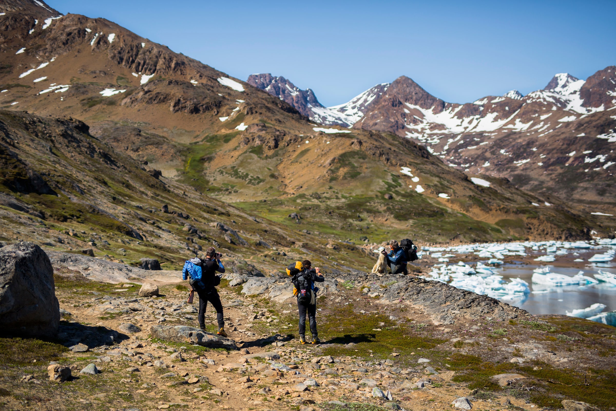 Three hikers with dog outside Tasiilaq. Photo- Aningaaq Rosing Carlsen - Visit Greenland