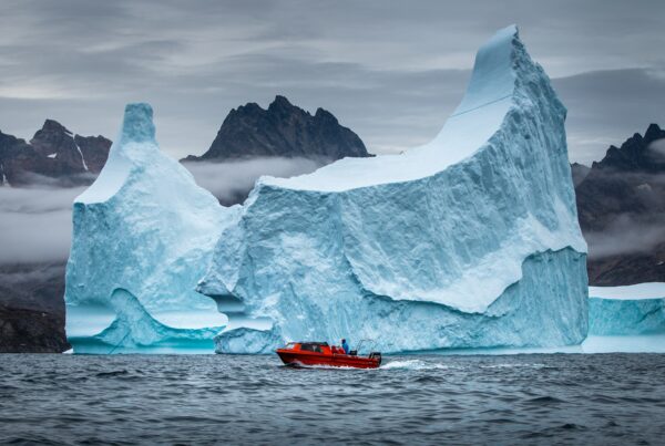 A boat from Arctic Dream passing a rather large iceberg near Tasiilaq in East Greenland. Photo: Mads Pihl - Visit Greenland